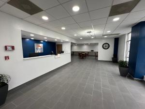 un vestíbulo de oficina con una sala de espera con paredes azules en Suburban Studios Chester I-95, en Chester