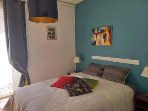 a bedroom with a bed and a blue wall at Appartement cosy 60m², proche gare St Roch et centre. in Montpellier