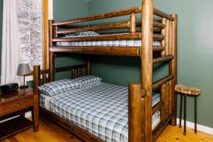 1 dormitorio con litera de madera y mesa de madera en Dingle Run Lodge at Sir Sam's, en Haliburton