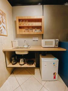a kitchen with a sink and a microwave at Blue in Igrejinha