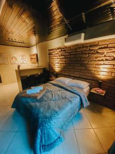 a large bed in a room with a brick wall at Blue in Igrejinha