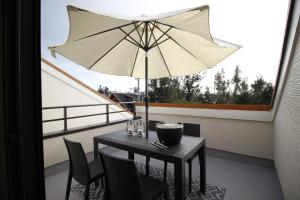 een tafel met een parasol op een balkon bij HOPE VILLA Onna-son - Vacation STAY 52846 in Inbu