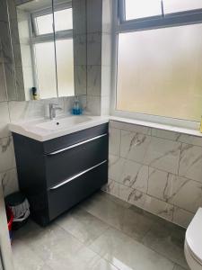 a bathroom with a sink and a window at Inviting 4-Bed House in Leeds in New Malden