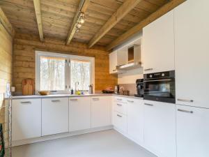 cocina con armarios blancos y techo de madera en Scilla, en Soesterberg