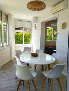 ein Esszimmer mit einem weißen Tisch und Stühlen in der Unterkunft Villa Tahitienne in Frontignan