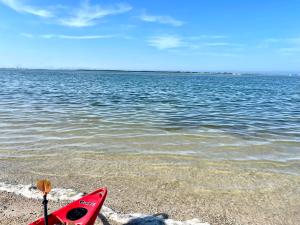 a red kayak sitting on the beach next to the water at Tampa Heights Bungalow in Tampa
