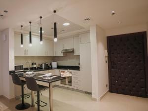 eine Küche mit einem Tisch und Stühlen sowie einer schwarzen Tür in der Unterkunft Luxury apartment Rafal Tower شقة فاخرة برج رافال in Riad