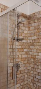 La salle de bains est pourvue d'une douche et d'un mur en briques. dans l'établissement Villa Competa, à Cómpeta