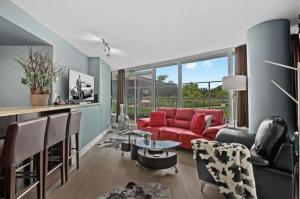 ein Wohnzimmer mit einem roten Sofa und Stühlen in der Unterkunft Luxury Designer Condo In The Heart Of Downtown - Best Location! in Vancouver
