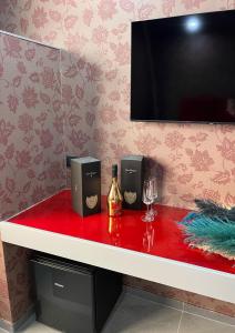 un contatore rosso con altoparlanti e un bicchiere di vino di Hotel El Pamas a Mugnano di Napoli