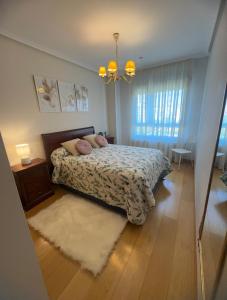 a bedroom with a bed with a rug and a window at Habitaciones De Lujo Con Hermosas Vistas A La Cuidad in Burgos