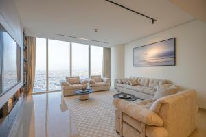 ein Wohnzimmer mit Sofas und einem TV mit großen Fenstern in der Unterkunft Luxury apartment Rafal Tower شقة فاخرة برج رافال in Riad