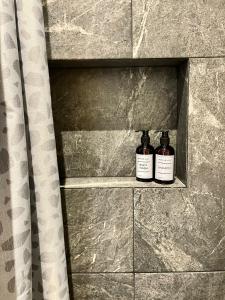 two bottles of whiskey sitting on a shelf in a shower at CASA ALDAMA- Style & Convenient Apartments in Cancún +59 photos