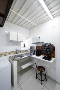uma cozinha branca com um balcão e uma cadeira em 46 LOFT TRIPLO · Mini apartamento em Metrô Jabaquara e EXPO em São Paulo