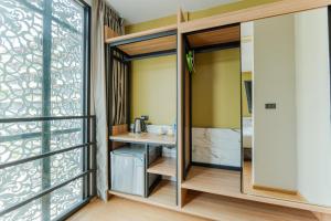 um quarto com portas de vidro deslizantes e uma casa de banho com um lavatório em Sky Wave Patong em Praia de Patong