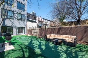 a backyard with a couch in the grass at Charming 2BR Bkyrd Near Williamsburg in Brooklyn