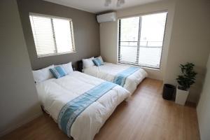 duas camas num quarto com duas janelas em HOPE VILLA Onna-son - Vacation STAY 52850 em Inbu