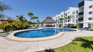 a swimming pool in a resort with a gazebo at Hermoso y cómodo departamento en Manzanillo in Manzanillo