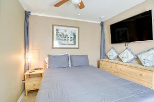 1 dormitorio con 1 cama y TV en la pared en Colorful Clearwater Home about 5 Mi to the Beach!, en Clearwater