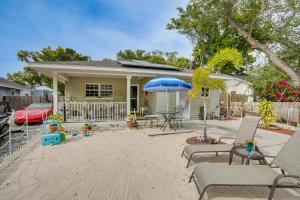 a house with a patio with chairs and an umbrella at Colorful Clearwater Home about 5 Mi to the Beach! in Clearwater