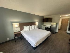 1 dormitorio con 1 cama blanca grande y cocina en Suburban Studios Chester I-95, en Chester