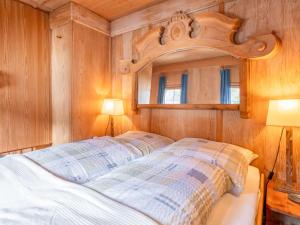 a bedroom with a bed with a wooden wall at Zinnhäusel in Alpbach