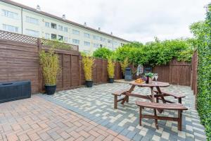 a patio with a table and benches and a building at Hayes Home - Easy links to LHR and London in Northolt