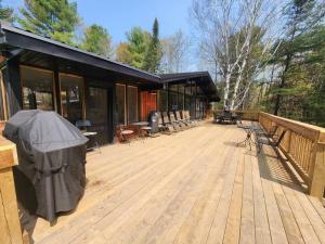 een houten dek met een gebouw met een vuilnisbak bij Red Cedar Chalet on Brady Lake in Hindon Hill +25 foto's