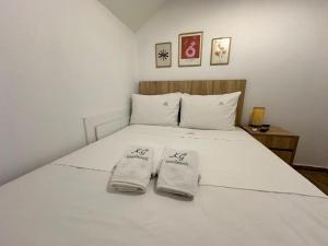 a bedroom with a white bed with two towels on it at K.G APARTMENT 2 in Pefkohori