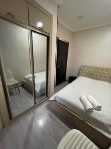 een slaapkamer met een grote spiegel en een bed bij Guest House Ana in Borjomi +13 foto's