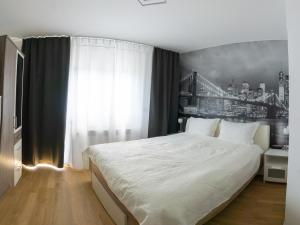 a bedroom with a bed with a black and white wall at Apartmani Jastreb 2 in Jastrebarsko