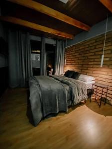 1 dormitorio con cama y pared de ladrillo en Apto Aventus, en Igrejinha