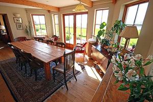 a dining room with a wooden table and chairs at Netherton Farm B&B in Culbokie