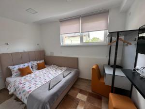um pequeno quarto com uma cama e uma janela em Ravne Energy Apartments em Visoko