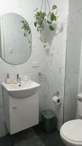 a bathroom with a sink and a mirror and a toilet at Mini Apartamento Vista Verde in Lima