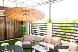 a patio with chairs and a table and an umbrella at LB Pietz Pension House in Cordova