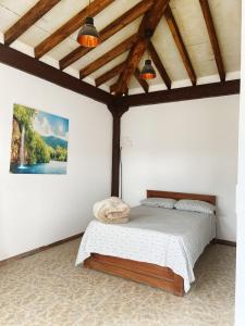 ein Schlafzimmer mit einem Bett in einem Zimmer mit Holzdecken in der Unterkunft Hostal Inn II Rionegro in Rionegro