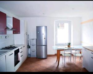 a kitchen with a stainless steel refrigerator and a table at Camiremare in Portovenere