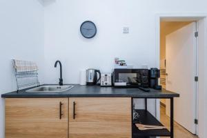 a kitchen counter with a sink and a microwave at Silver Street by Staycay in Bury