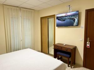 a bedroom with a bed and a table and a mirror at Hotel Sancho in Hospitalet de l'Infant
