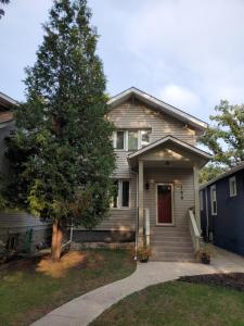 una casa con un árbol delante de ella en Homestay in cozy River Heights home, en Winnipeg