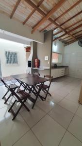 a table and chairs in a room with a kitchen at Casa no centro com 4 quartos e ar condicionado in São João Batista do Glória