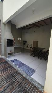 a kitchen with a stove and a table and chairs at Casa no centro com 4 quartos e ar condicionado in São João Batista do Glória