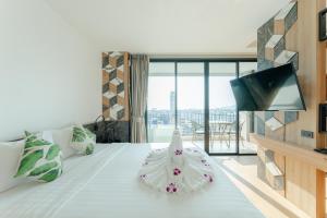 a hotel room with a white bed with a dress on it at Sky Wave Patong in Patong Beach