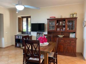 a dining room with a table and a tv at Villa Mimosa in Malfa