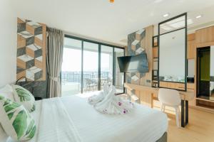 um quarto de hotel com uma cama e uma secretária com uma televisão em Sky Wave Patong em Praia de Patong