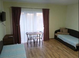 a living room with a table and a bed at Yellow apartments in Boryspilʼ