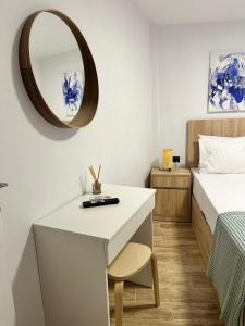 a bedroom with a white desk and a bed and a mirror at K.G apartment in Pefkohori