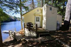 Hobie's Landing - Blissful lake side cottage - On Lake Winona في Ashland: مبنى صغير به مرسى بجانب نهر