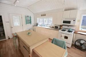 une cuisine avec une table et une cuisinière four supérieur dans l'établissement Hobie's Landing - Blissful lake side cottage - On Lake Winona, à Ashland 4 autres photos